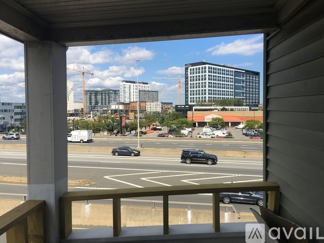 A view from a balcony looking out at a busy street with cars and buildings.