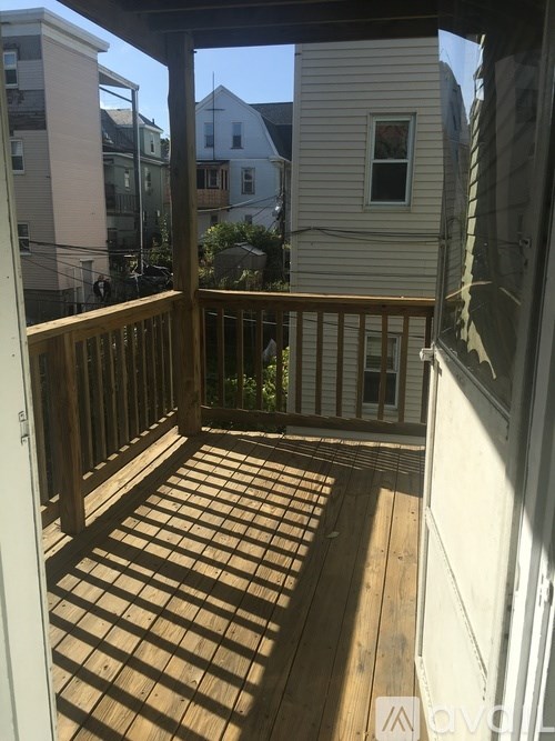 A wooden deck with a railing and a window.