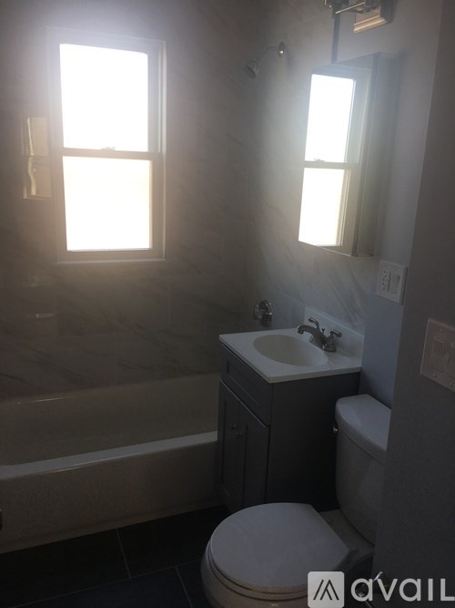 A bathroom with a toilet, sink, and bathtub.