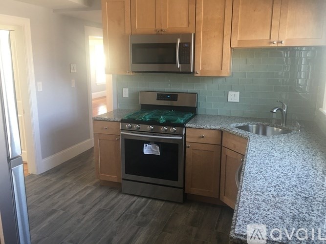 A kitchen with wooden cabinets and a stove top oven.