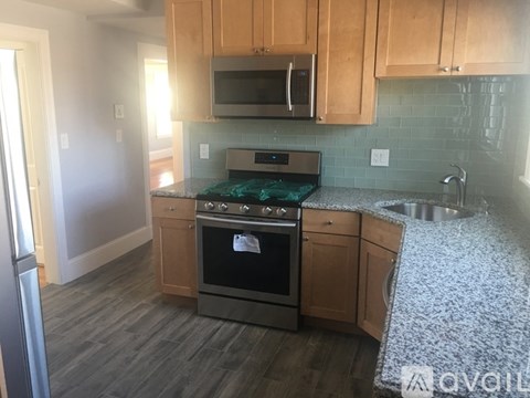 A kitchen with wooden cabinets and a stove top oven.