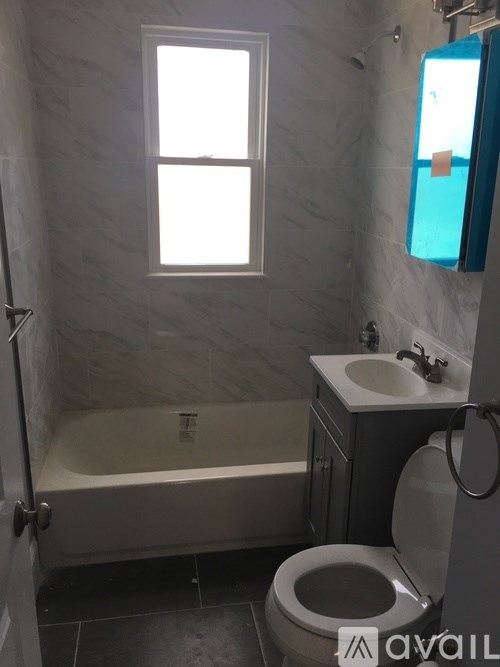 A bathroom with a toilet, sink, and bathtub.