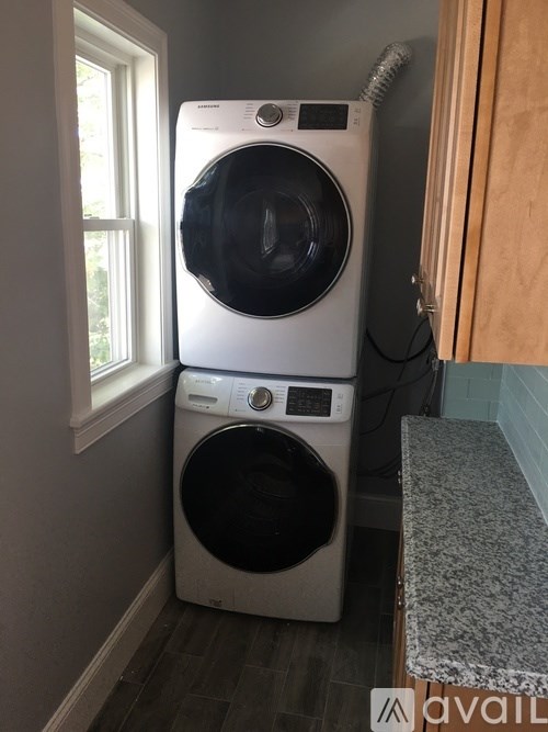 A white front loading washing machine in a laundry room.
