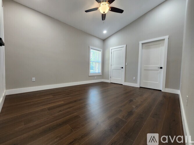 A room with wooden floors and a ceiling fan.