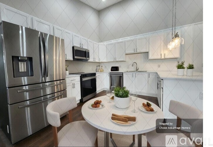 A modern kitchen with a table set for two.