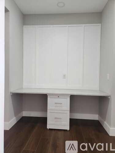 A white desk with drawers underneath it in a room.