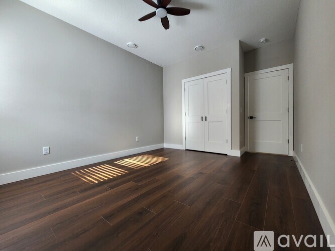 A room with wooden floors and a ceiling fan.