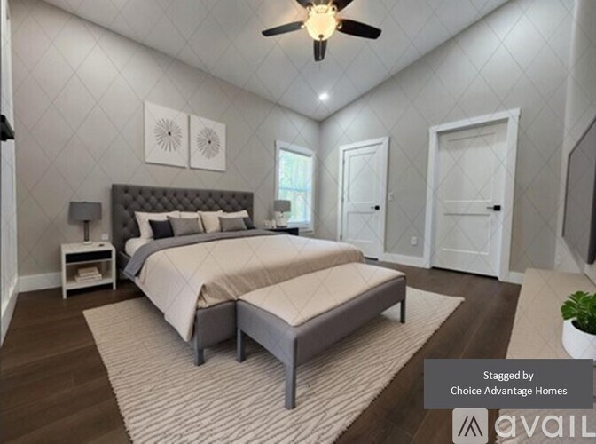 A bedroom with a large bed and a ceiling fan.