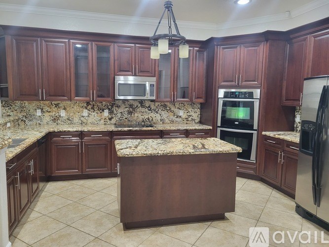 A kitchen with granite countertops and wooden cabinets.
