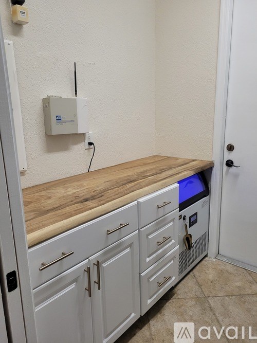 A kitchen with white cabinets and a wooden countertop.