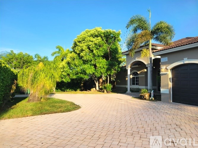 A grey door is in the middle of a white wall.