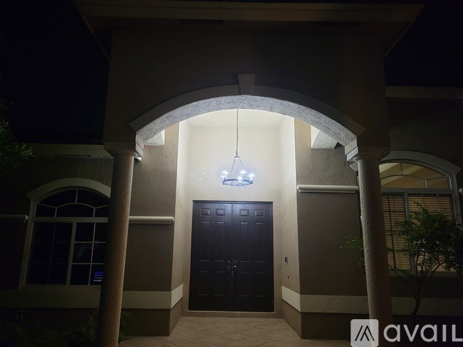 A building entrance with a black door and a hanging light fixture.