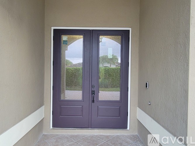A purple double door with a glass window and a handle.