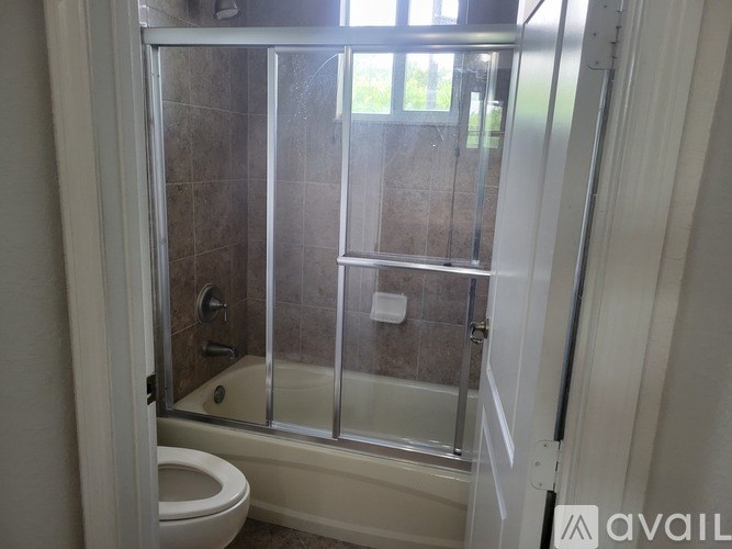 A bathroom with a toilet, tub, and shower.