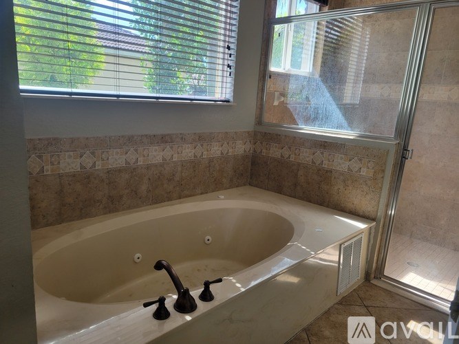 A bathroom with a large tub and a window.