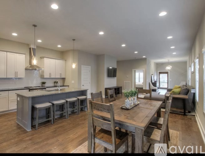 A modern kitchen with a wooden dining table and chairs.