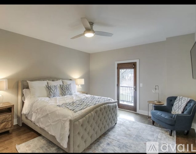 A bedroom with a large bed and a blue chair.