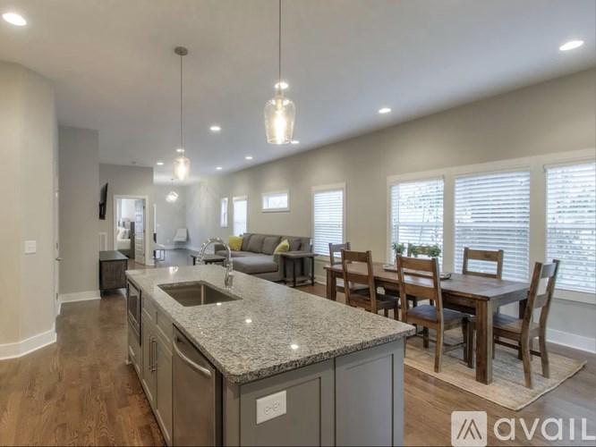 A kitchen with a granite countertop and a dining table with chairs.