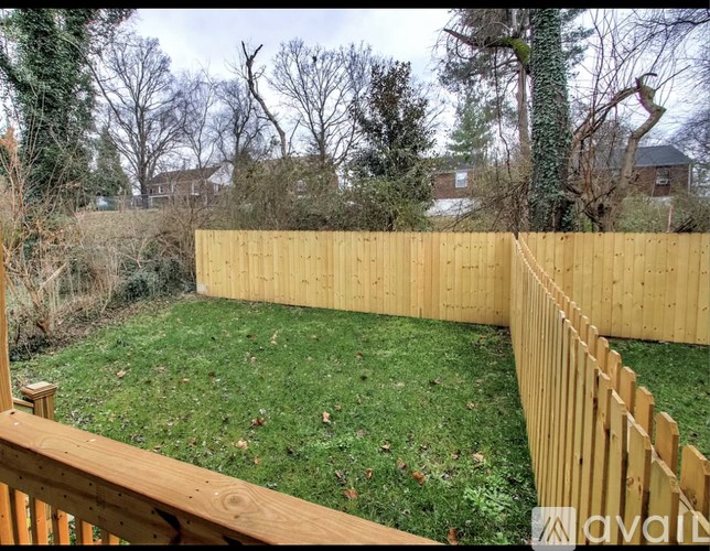 A backyard with a wooden fence and a grassy area.