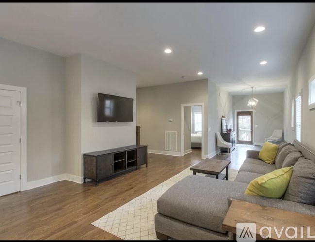 A living room with a grey couch and a wooden floor.