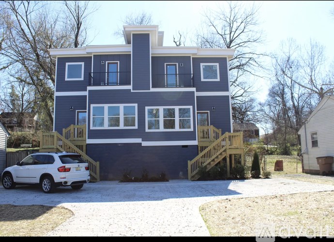 A blue house with a white car parked in front.