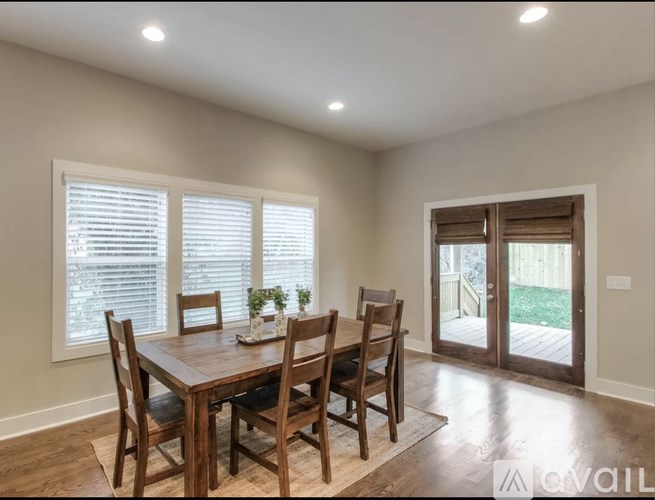 A dining room with a wooden table and chairs.