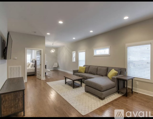 A living room with a grey couch and a wooden cabinet.