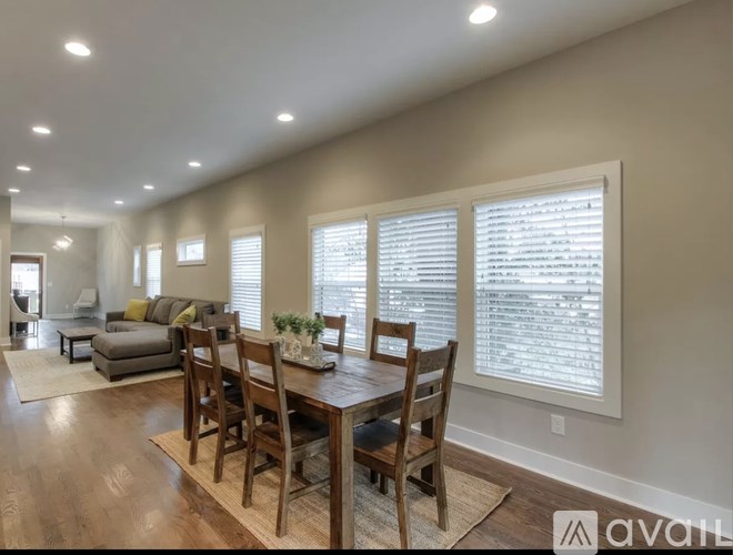 A dining room with a wooden table and chairs.