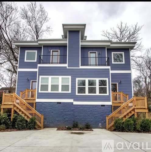 A blue house with a balcony and a staircase leading to it.