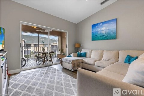 A living room with a couch, a chair, and a painting on the wall.