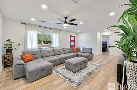 A living room with a grey sectional sofa and a rug.