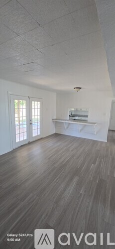 A room with wooden flooring and white walls.