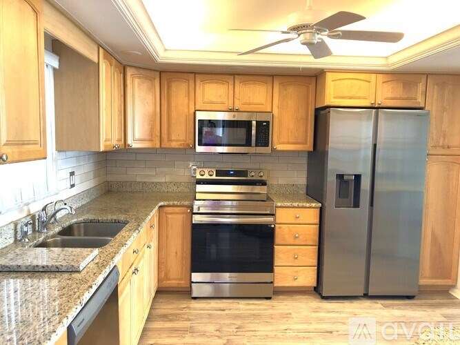 A kitchen with wooden cabinets and stainless steel appliances.