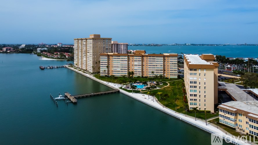 A large building complex sits on the shore of a body of water.