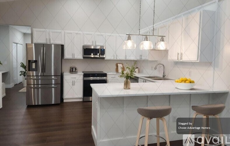 A modern kitchen with white cabinets and a central island.