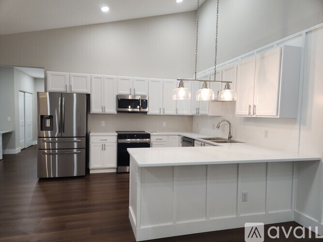 A kitchen with white cabinets and a white island.