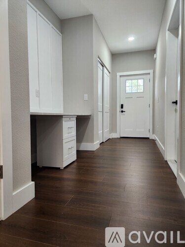A hallway with wood floors and white doors.