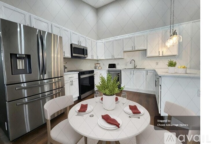 A modern kitchen with a dining table set for two.