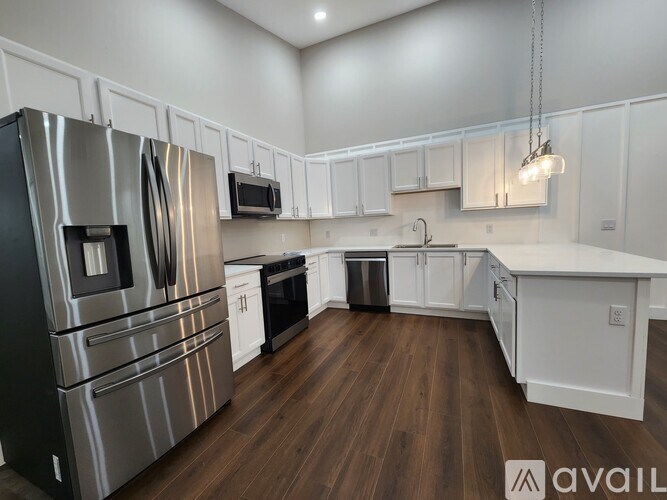A kitchen with stainless steel appliances and white cabinets.