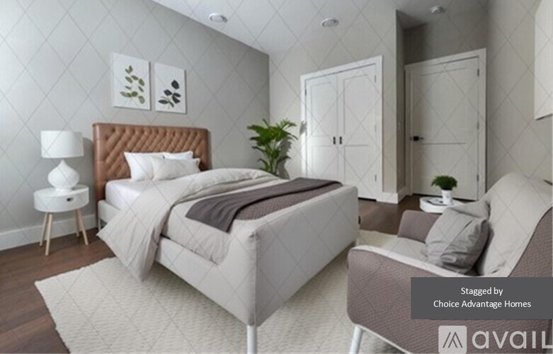 A bedroom with a large bed and a chair.