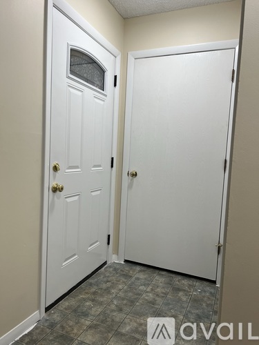 Two white doors with gold knobs in a hallway.