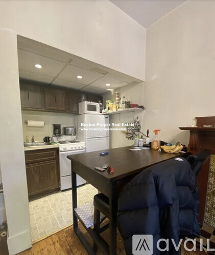 A kitchen with a table and a washing machine.