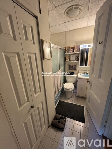 A bathroom with a toilet, sink, and mirror.