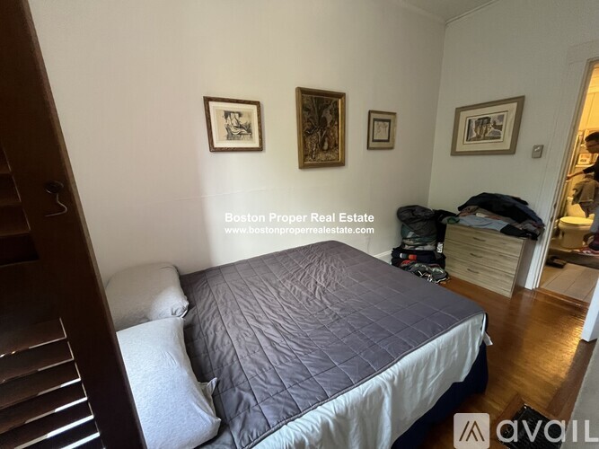 A bedroom with a bed, a dresser, and a painting on the wall.