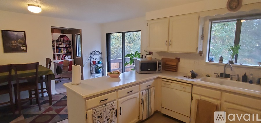 A kitchen with white cabinets and appliances.