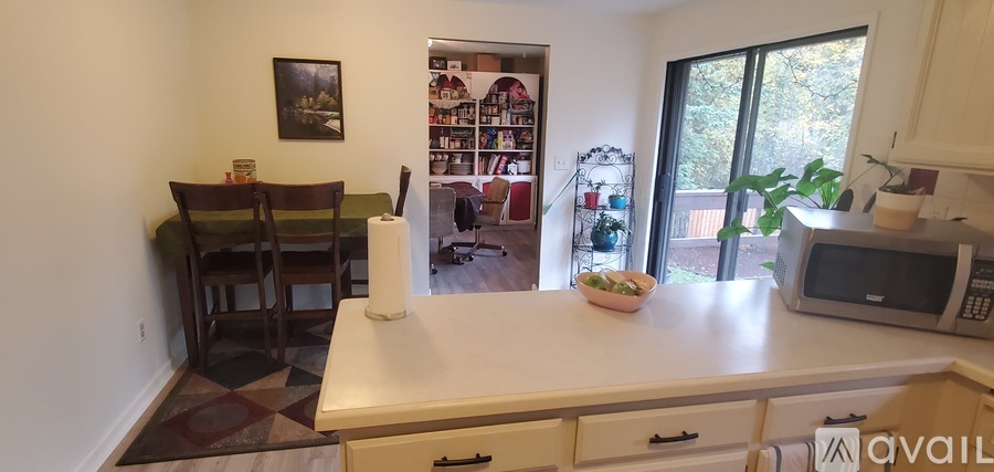 A kitchen with a white counter top and a microwave on it.