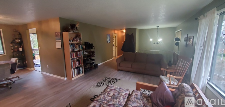A living room with a couch, a chair, and a bookshelf.