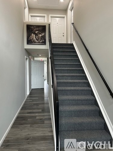 A staircase with a black and white picture on the wall.