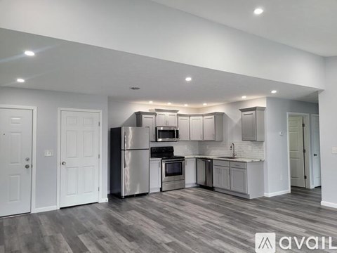A spacious kitchen with white cabinets and a stainless steel refrigerator.