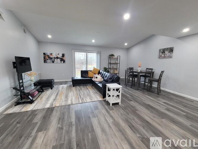 A living room with a grey floor and a white sofa.